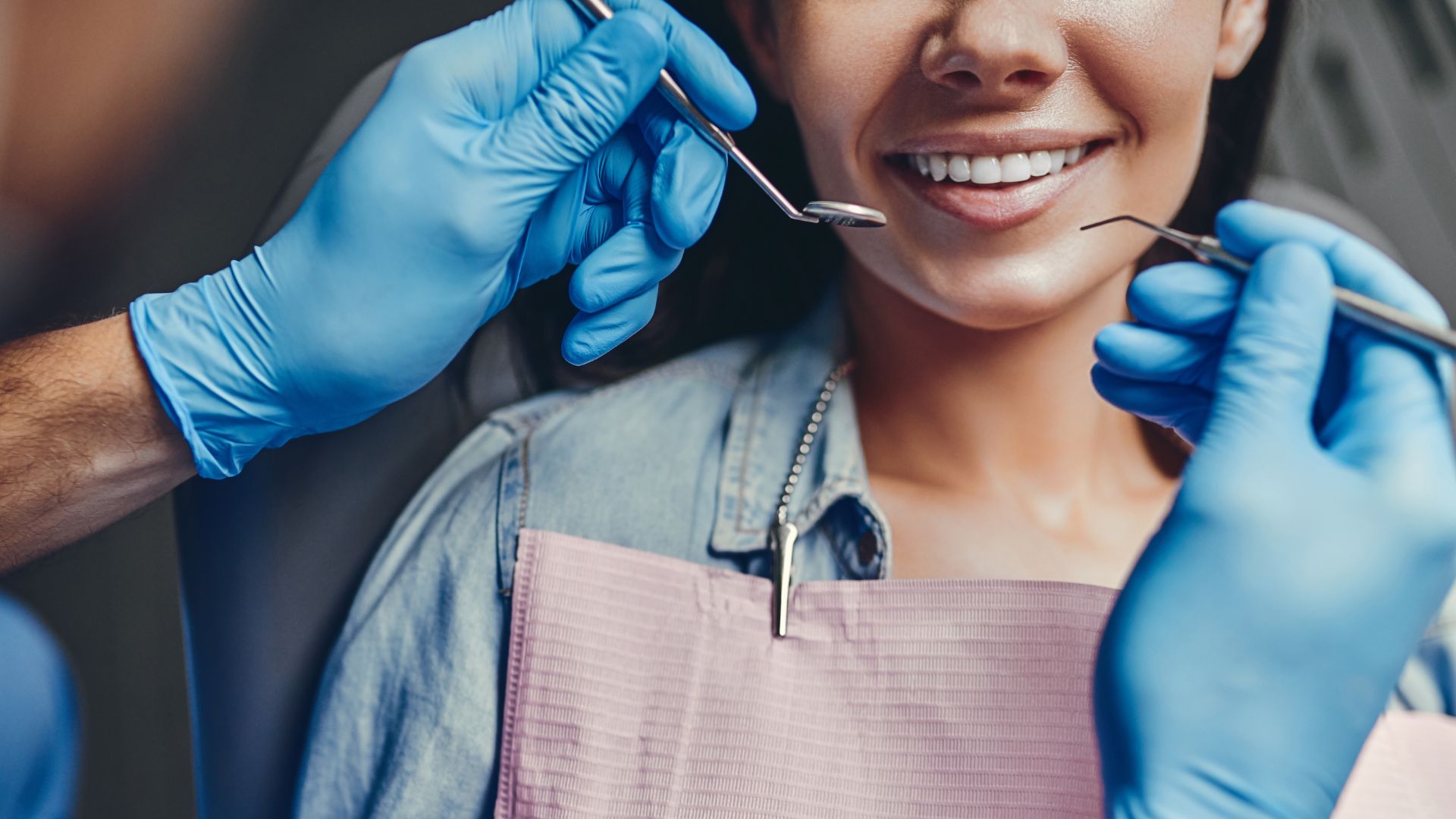 Dentist examining a smiling patient's teeth.