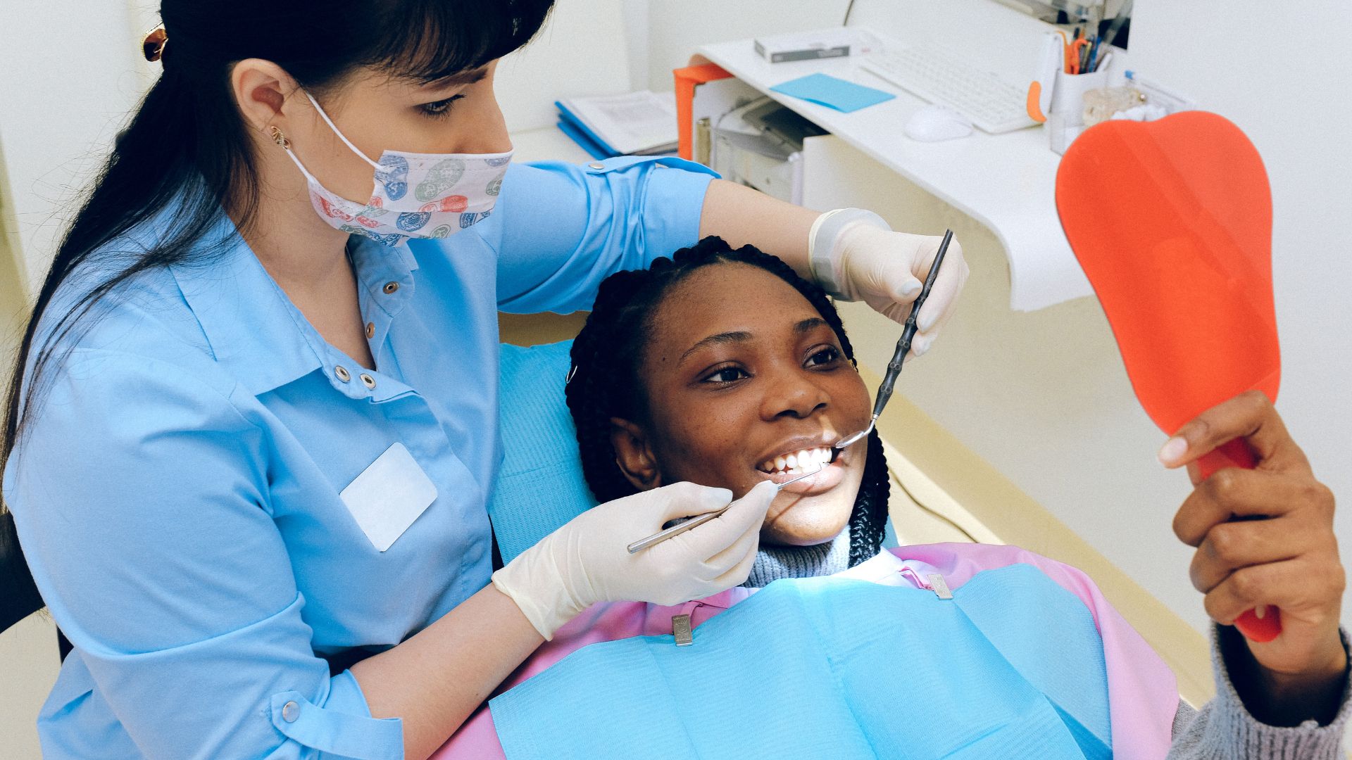Dentist examining patient's teeth with mirror.