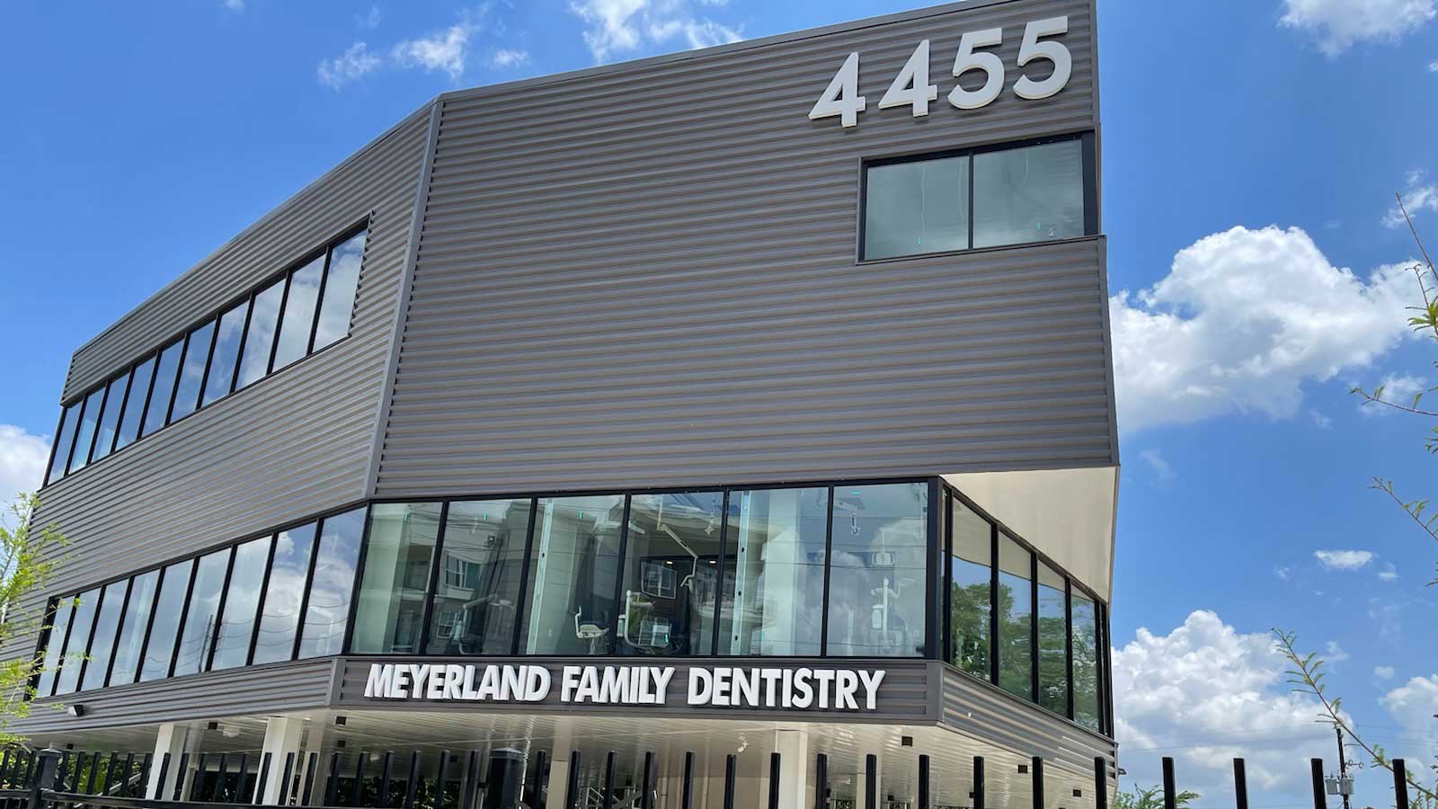 Modern dental clinic building under blue sky.