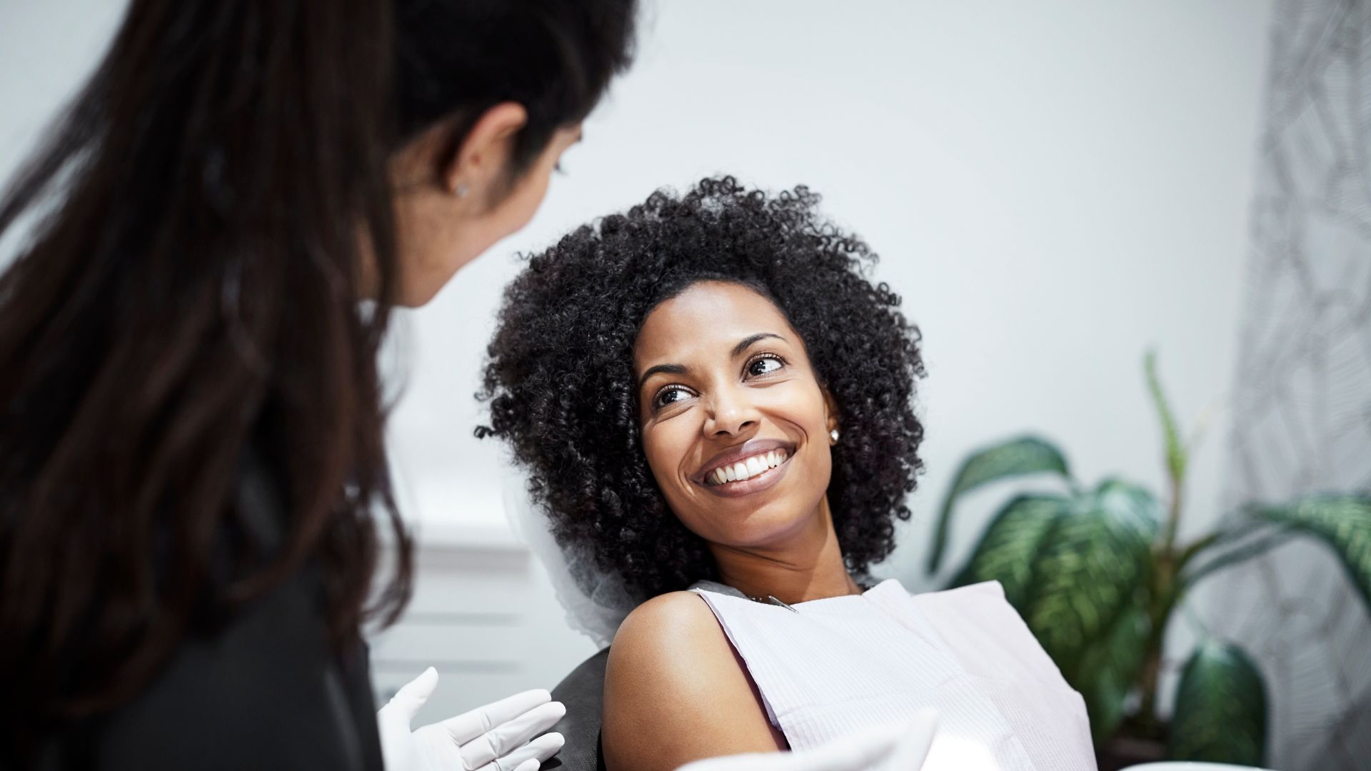 Woman smiling at dentist during appointment.