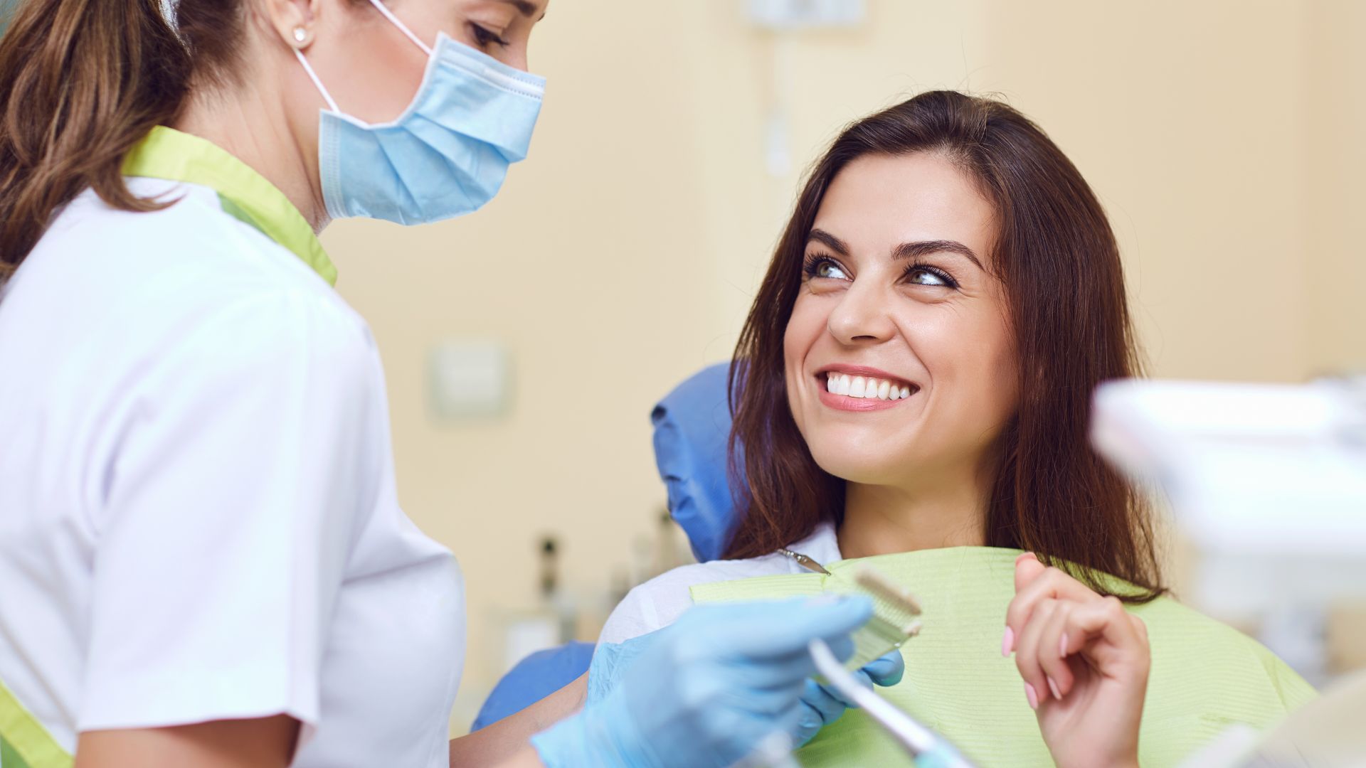 Dentist and patient smiling during check-up.