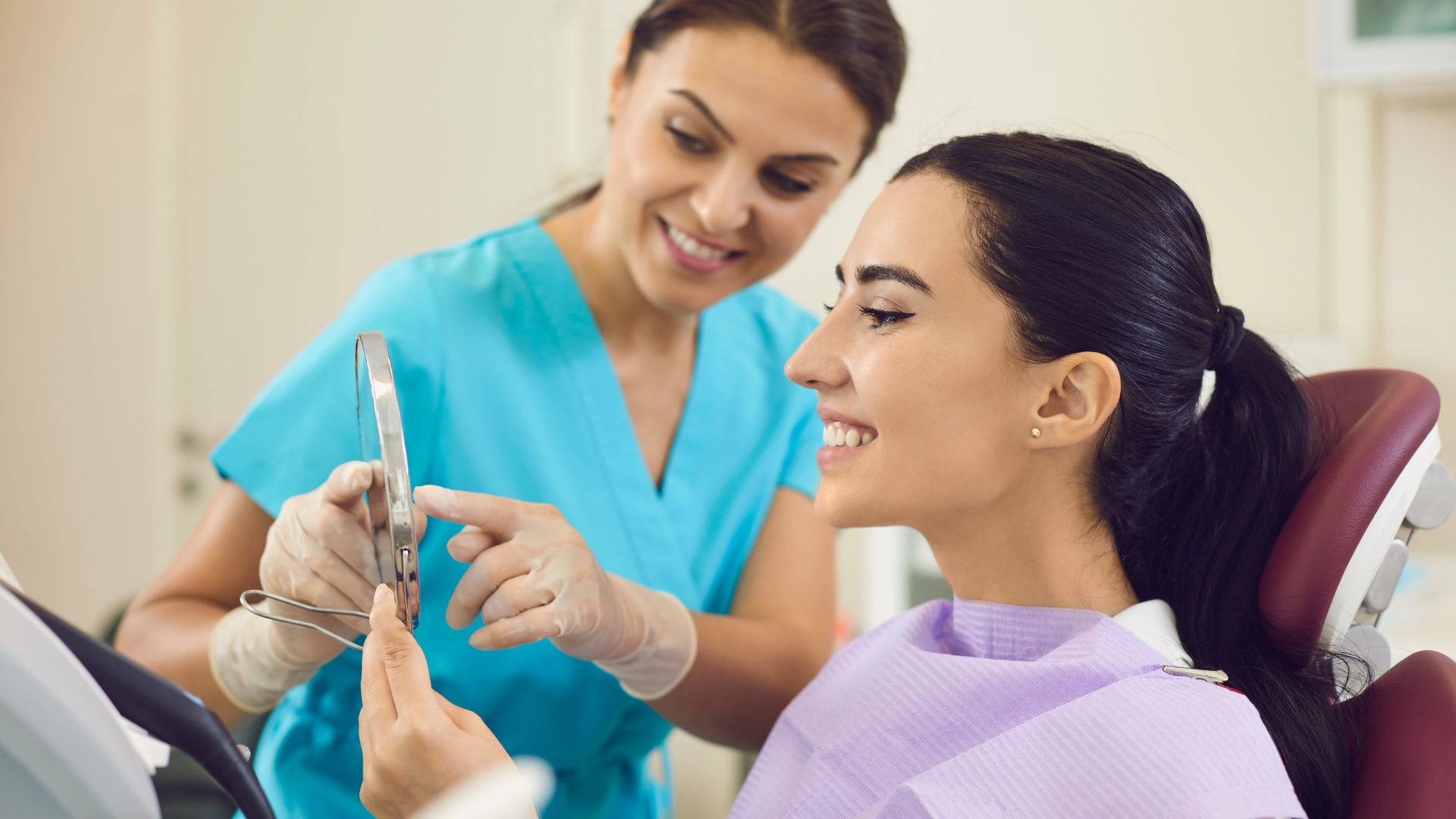 Dentist showing mirror to smiling patient.